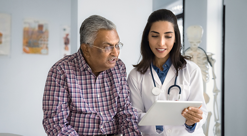 Doctor reviewing a file on her clipboard with a patient